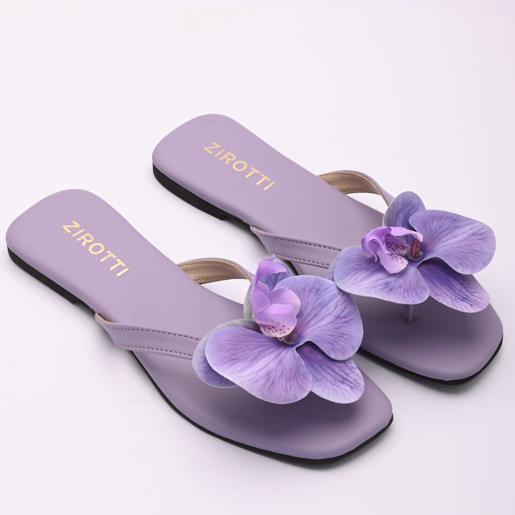 Purple strappy flat shoe with cushioned sole and round toe.