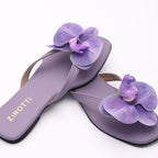 Purple strappy flat shoe with cushioned sole and round toe.
