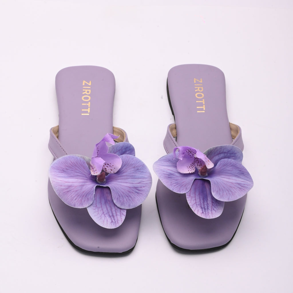Purple strappy flat shoe with cushioned sole and round toe.