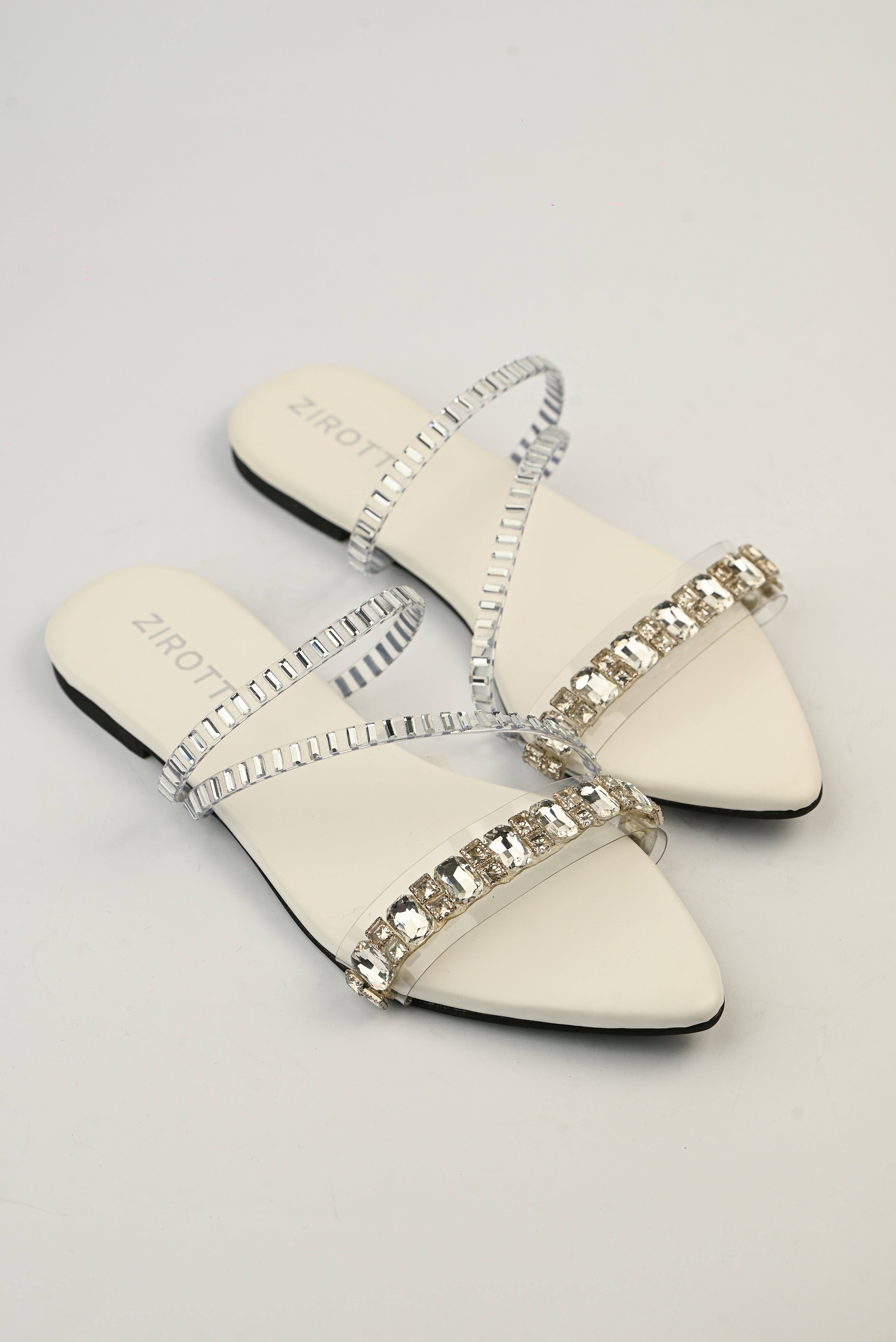 Orvia White women’s flat shoes with stylish stone detailing and comfortable sole.